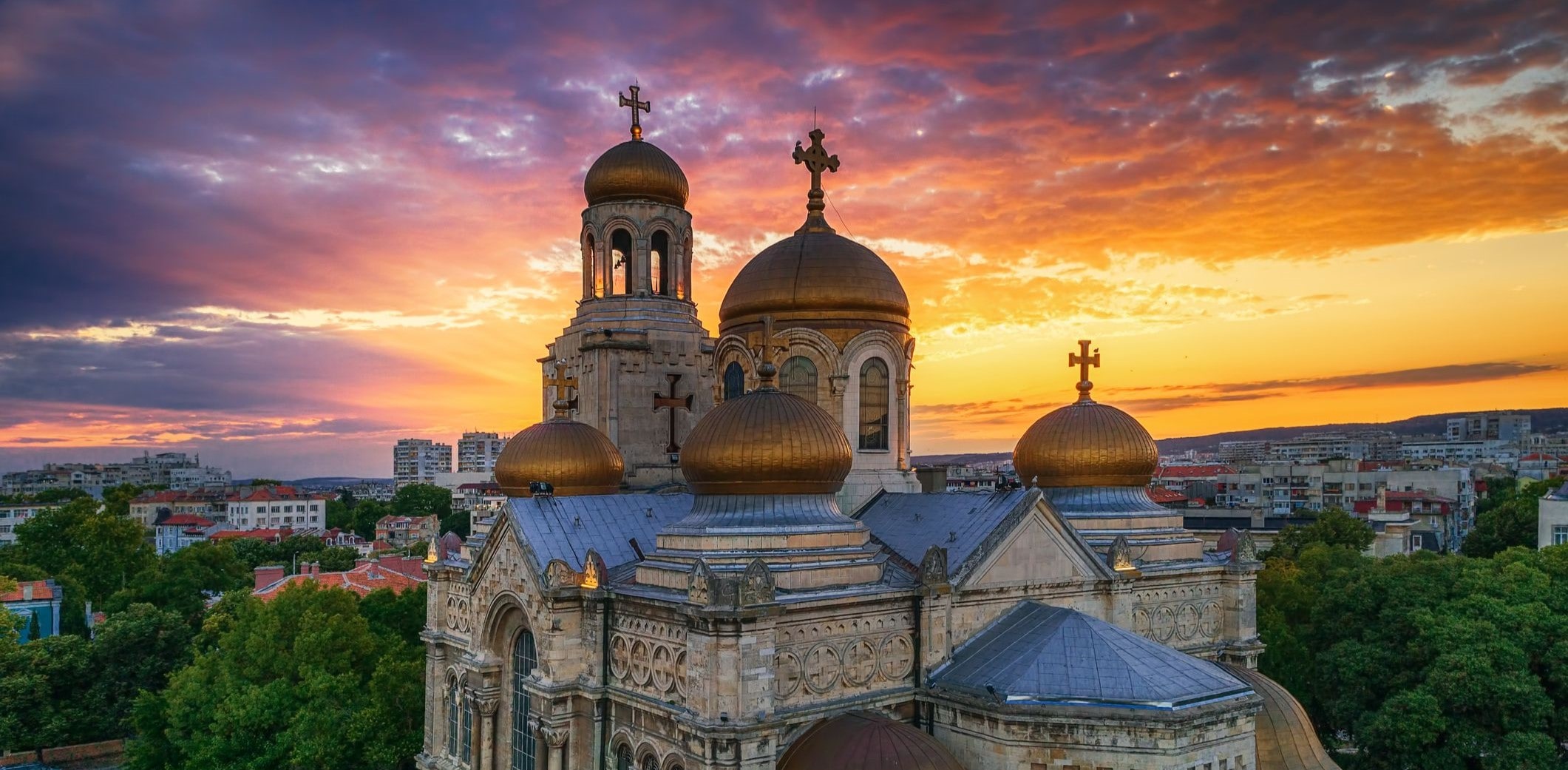 A golden-domed cathedral in Varna at sunset